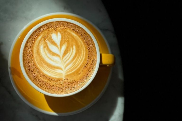 cappuccino v žltej šálke s podšálkou